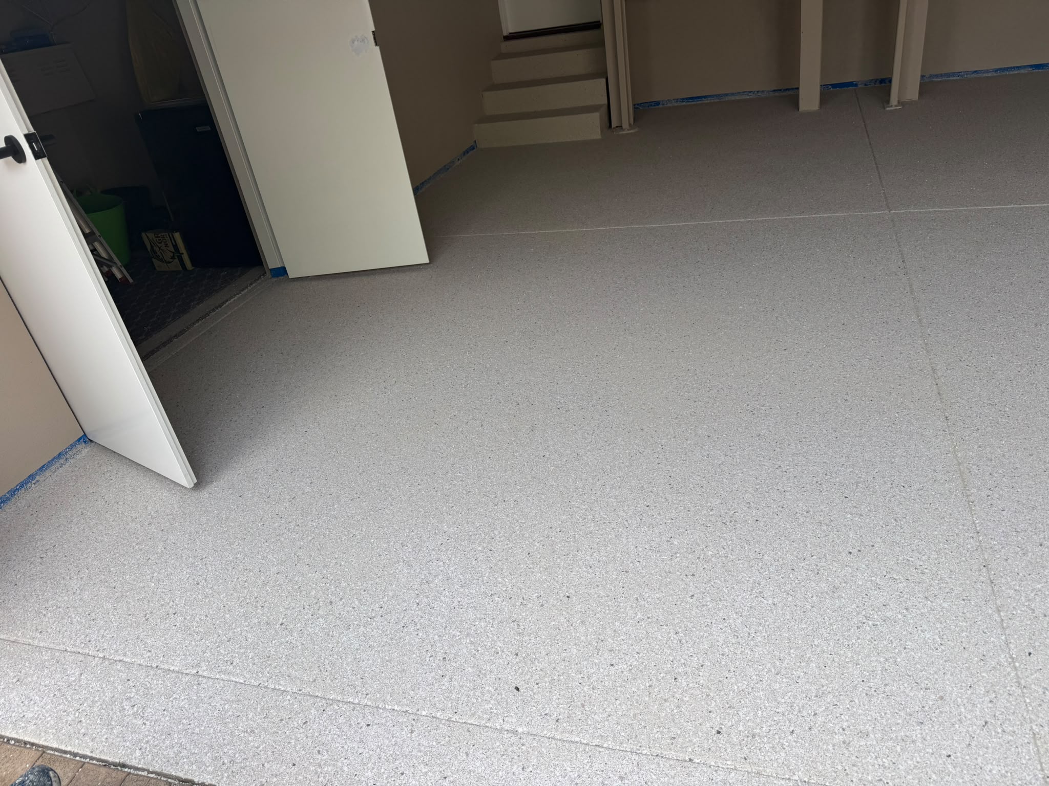 Durable residential garage epoxy flake floor coating with clean entryway finish